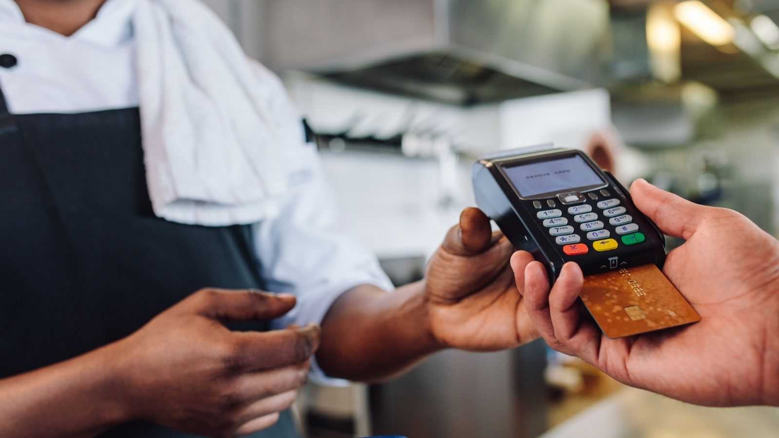 A merchant giving a payment terminal to a customer