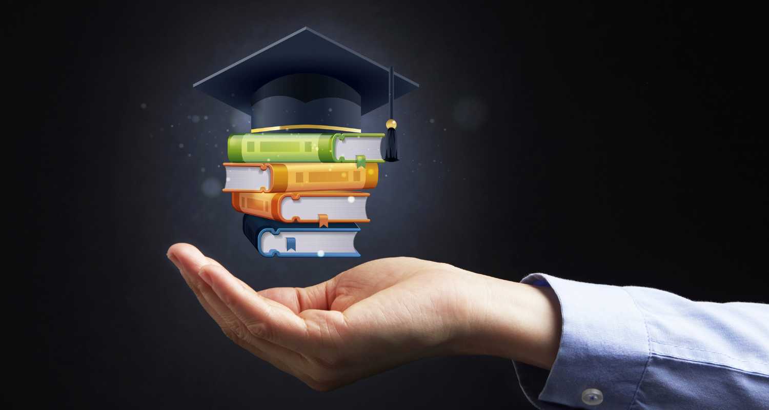 Floating books and a graduate cap above the hand