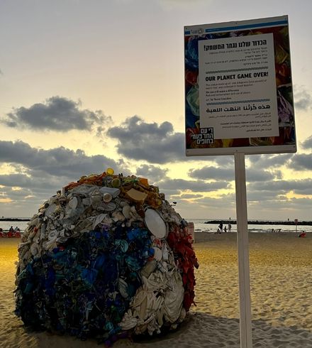 A huge ball made of used plastic with information about the pollution of the planet