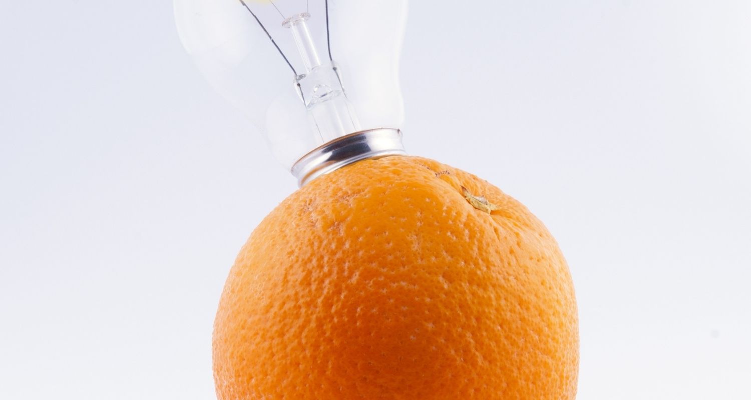 A light bulb sticking out of an orange