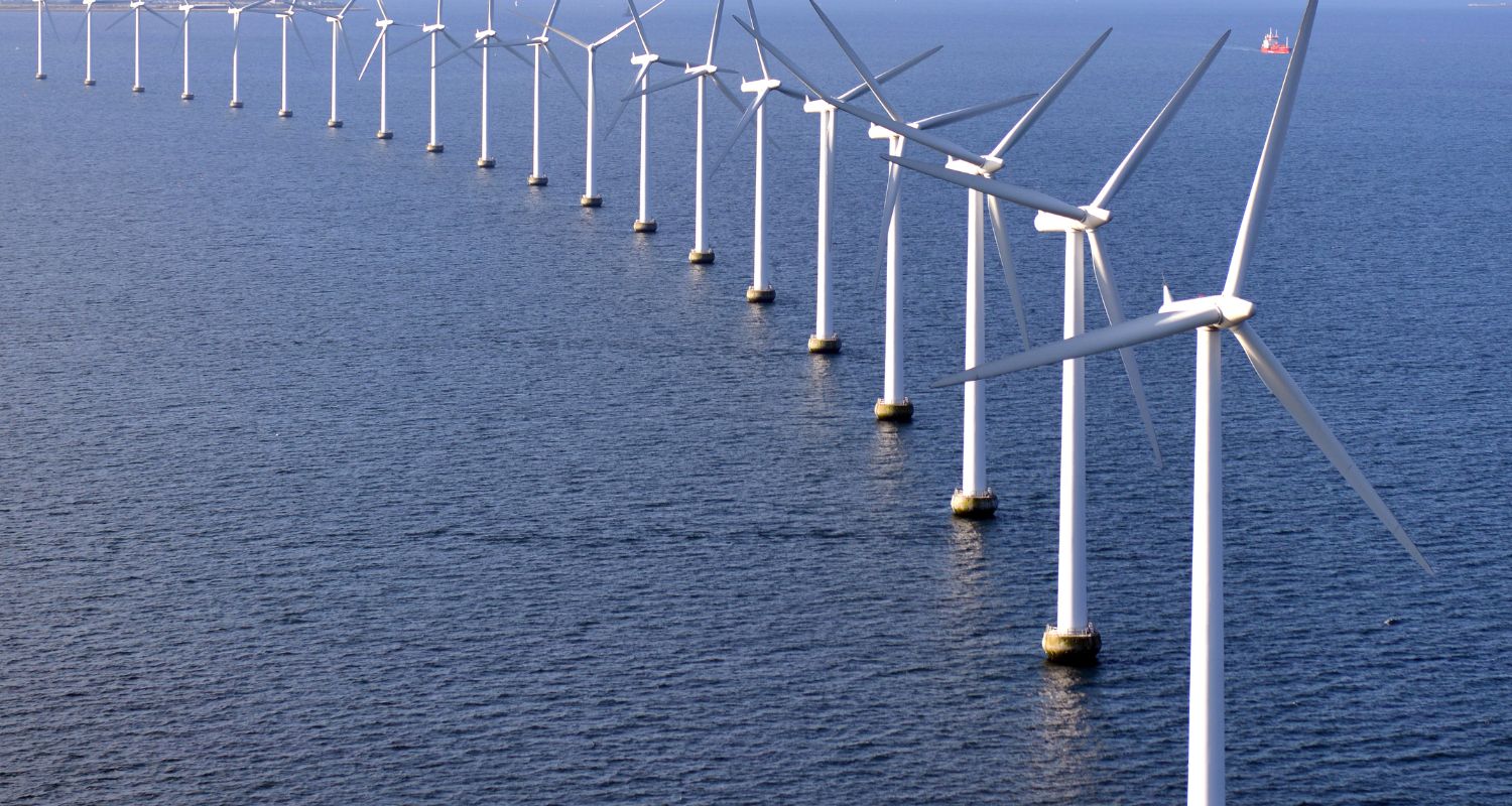 A row of windmills placed in a water reservoir