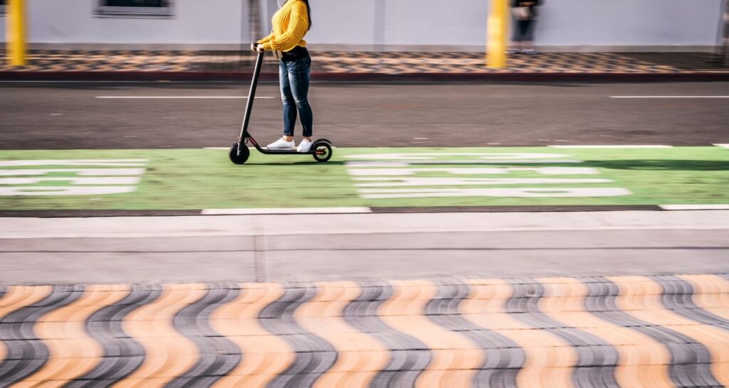 Young girl riding a scooter through the city
